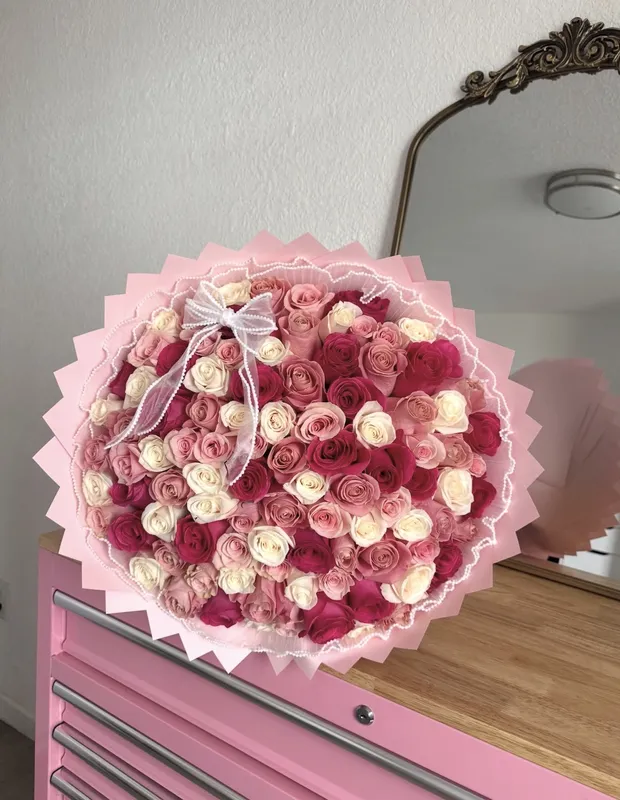 Signature Rose Bouquet — a full bouquet of blush and burgundy roses in pink wrap